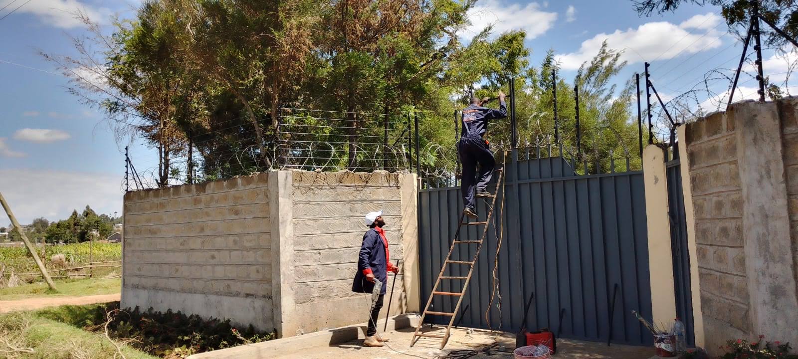 Electric fence perimeter wire being installed on wall-top brackets