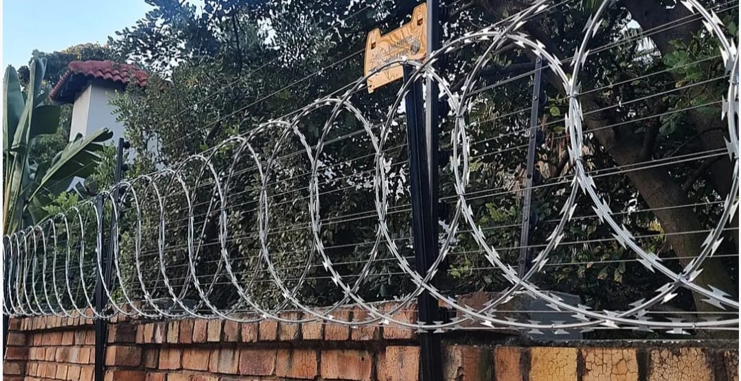 Completed electric fence perimeter installation on a boundary wall