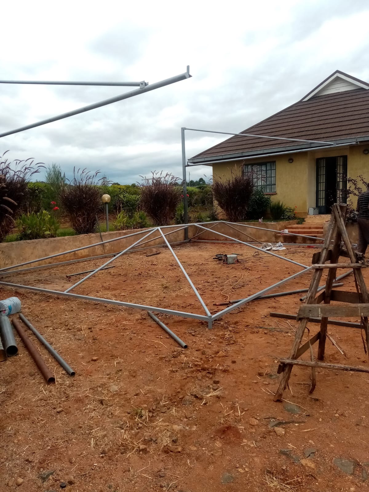 Cantilever car parking shade steel frame installation in Kitale, alternate angle with construction materials on site