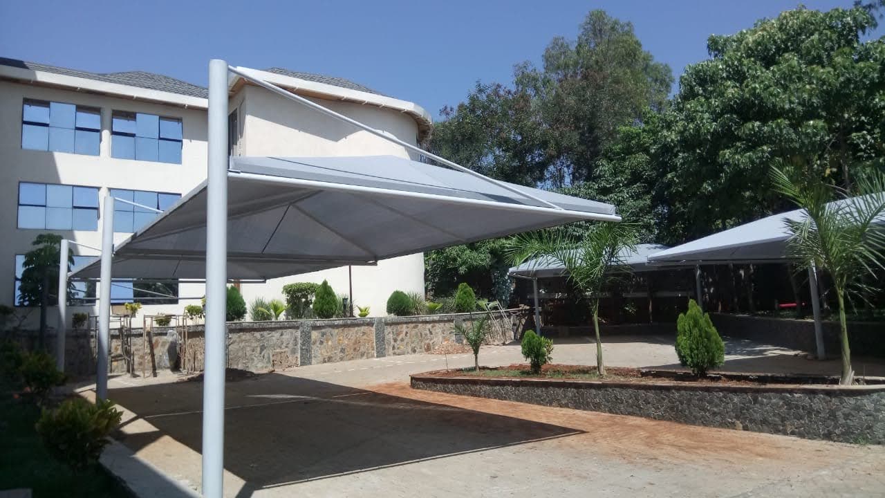 Grey tensile cantilever car parking shade structure completed at a multi-storey property in Malindi