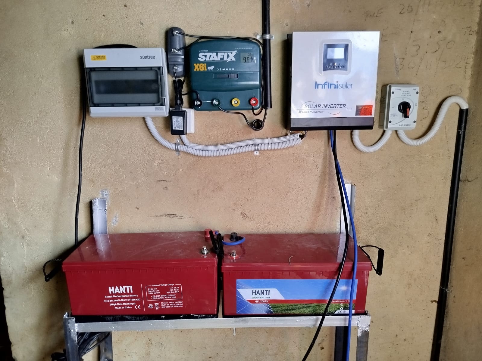 Stafix X6i electric fence energizer, Infinisolar hybrid inverter, and Hanti battery bank wall-mounted at a property in Emali