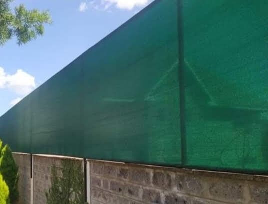 Green privacy shade net fitted along the top of a stone boundary wall in Nairobi