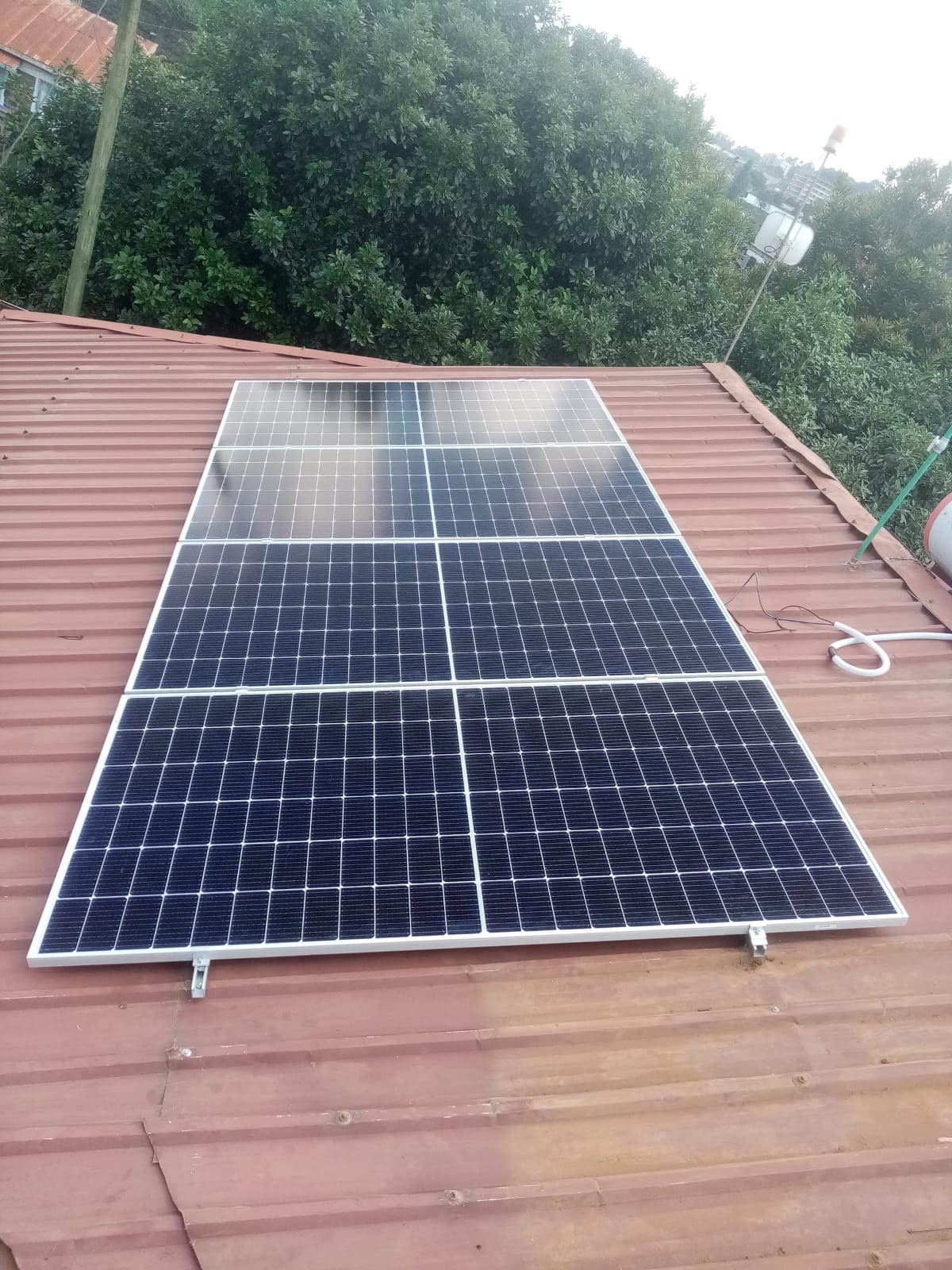 Monocrystalline solar panel array mounted on a red metal roof in Kiambu as part of a 3kW solar backup system