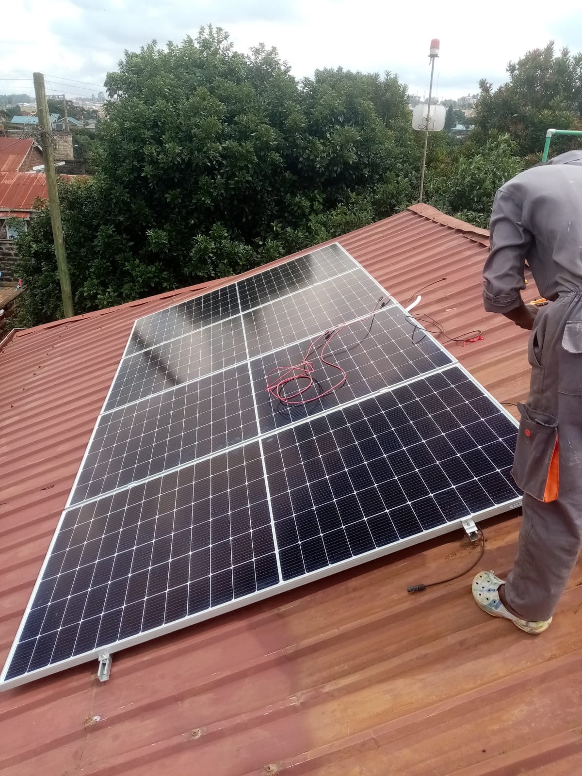 Technician wiring a monocrystalline solar panel on a rooftop in Kiambu, part of a 3kW solar backup installation