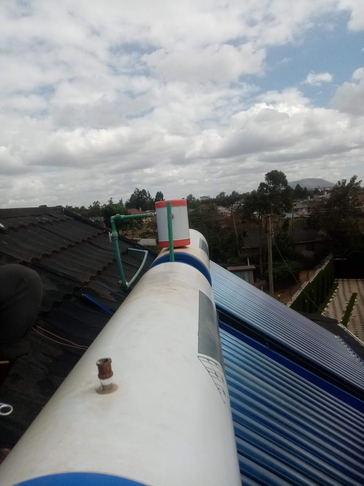 Close-up of a solar water heater tank valve fitting on a rooftop in Kiambu, second tank visible alongside