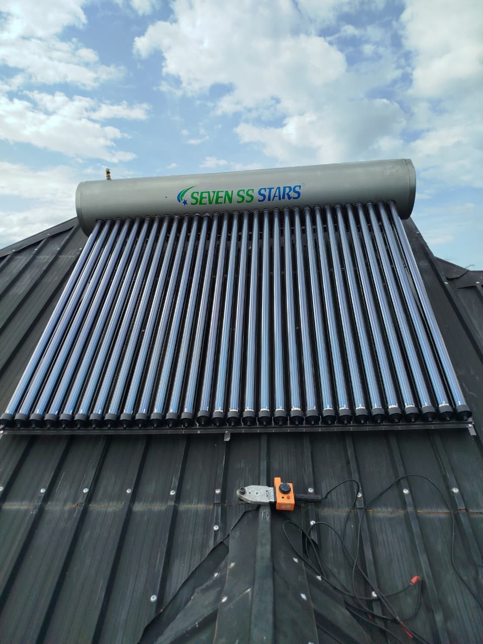 Solar water heater tank and collector tubes mounted on a metal roof in Kenya